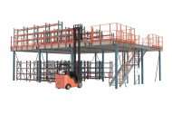 Large structural steel mezzanine platform built over ground-level pallet racking, featuring an orange forklift, stairs, and safety railings.