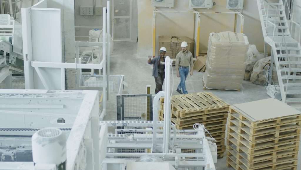 two people walking through warehouse getting painted white | Speedrack West